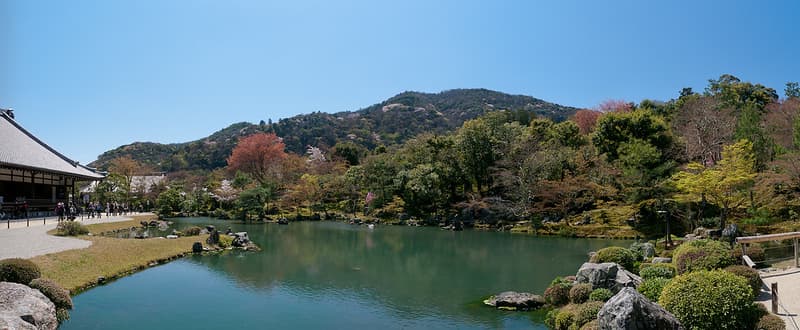 Góc nhìn rộng của vườn và hồ ở Chùa Tenryu-ji, Kyoto, với đồi núi phía sau