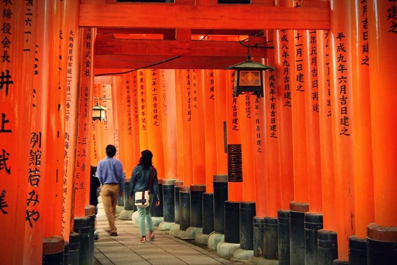 Một cặp đôi đi dạo qua Fushimi Inari Taisha đỏ rực, Kyoto