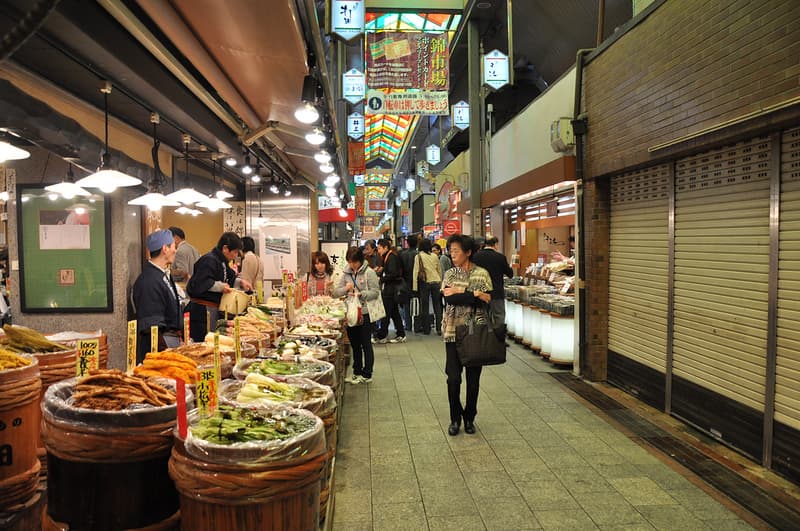 Khách hàng xem quầy bán rau tươi ở Chợ Nishiki Ichiba, Kyoto