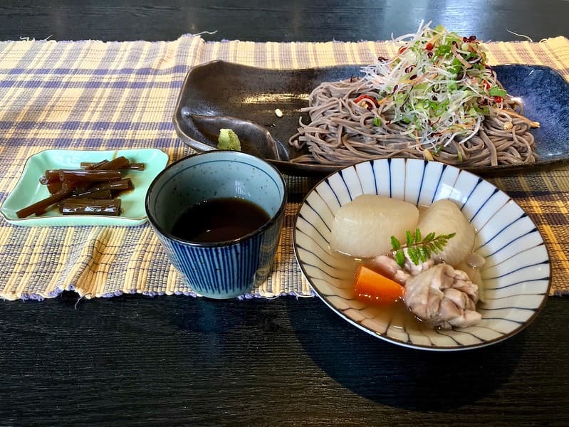 Mì kiều mạch soba với rau củ, gà hầm và rau củ, thân cây ngưu bàng om và nước chấm mì.