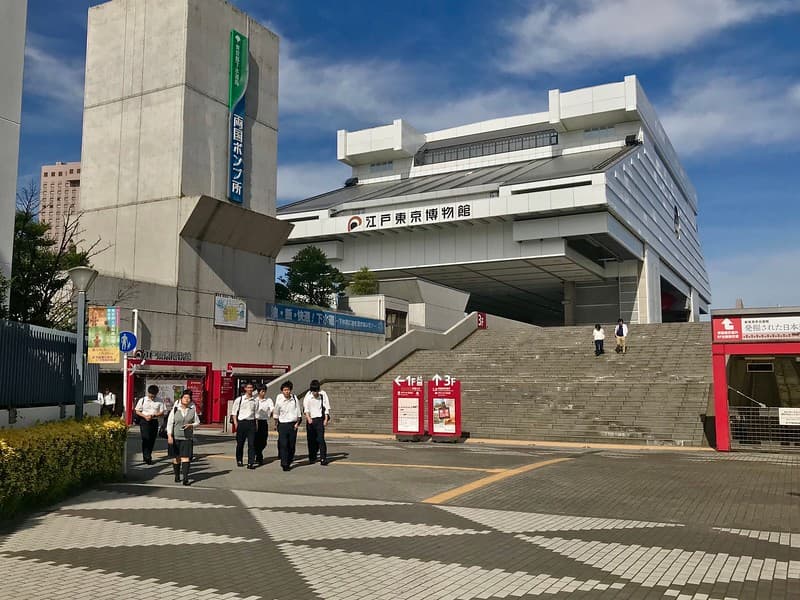 Quang cảnh các bậc thang dẫn lên cấu trúc hiện đại của Bảo tàng Edo-Tokyo với một nhóm học sinh lớn tuổi ở phía dưới