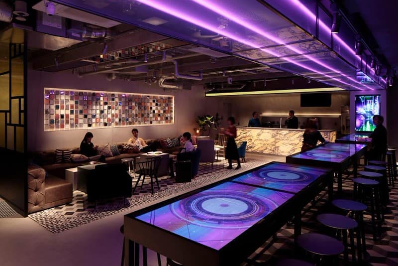 Ánh neon hồng và ánsáng tạo không khí khi mọi người thư giãn trong phòng lounge của khách sạn capsule The Millennials ở Tokyo Ánh neon hồng và ánh sáng tạo không khí khi mọi người thư giãn trong phòng lounge của khách sạn capsule The Millennials ở Tokyo