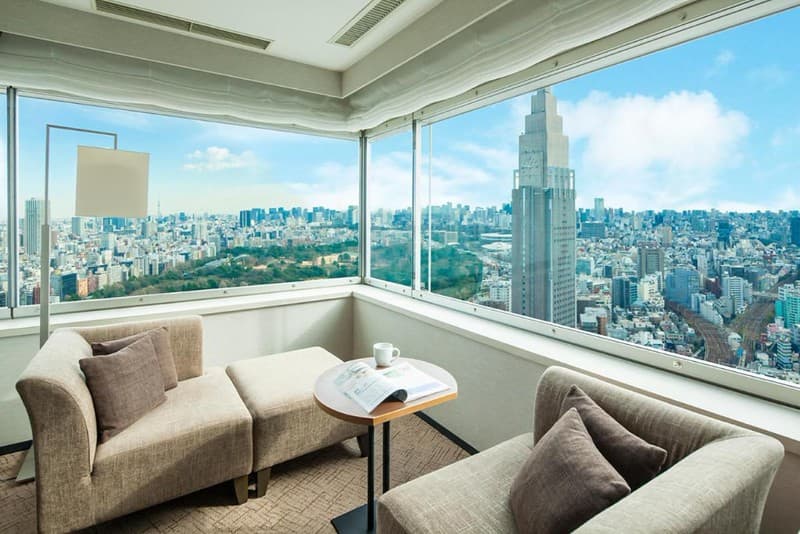 Phòng góc cho khách trên các tầng cao của Khách sạn Century Southern Tower, Shinjuku, Tokyo, Nhật Bản, với ghế dài và ghế bành, nhìn ra các tòa nhà chọc trời thành phố và khu vực công viên rộng lớn Phòng góc cho khách trên các tầng cao của Khách sạn Century Southern Tower, Shinjuku, Tokyo, Nhật Bản, với ghế dài và ghế bành, nhìn ra các tòa nhà chọc trời thành phố và khu vực công viên rộng lớn