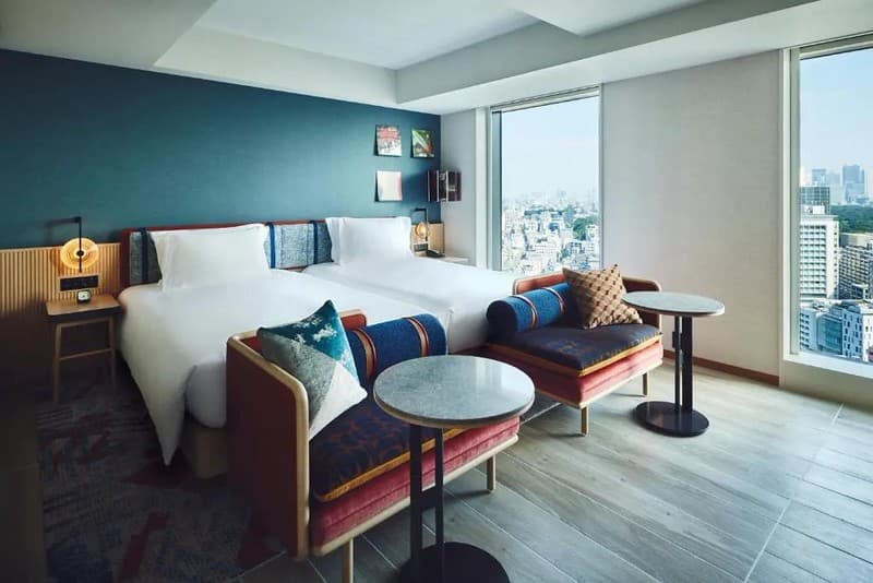 Phòng cho khách giường đơn trong Khách sạn Hotel Indigo Tokyo Shibuya, Nhật Bản, với hai giường đơn ghép liền với hai ghế sofa ở chân giường và sàn gỗ tẩy trắng, cũng như view thành phố Phòng cho khách giường đơn trong Khách sạn Hotel Indigo Tokyo Shibuya, Nhật Bản, với hai giường đơn ghép liền với hai ghế sofa ở chân giường và sàn gỗ tẩy trắng, cũng như view thành phố
