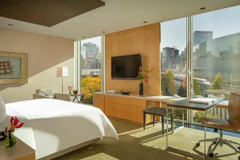 Phòng cho khách đôi sạch sẽ, đương đại trong Khách sạn Four Seasons Hotel Tokyo, Nhật Bản, với bàn làm việc hình chữ L với ghế làm việc và ghế đẩu, tủ ngực có ngăn kéo, ghế bành và tầm nhìn sáng sủa ra các đường tàu shinkansen Phòng cho khách đôi sạch sẽ, đương đại trong Khách sạn Four Seasons Hotel Tokyo, Nhật Bản, với bàn làm việc hình chữ L với ghế làm việc và ghế đẩu, tủ ngực có ngăn kéo, ghế bành và tầm nhìn sáng sủa ra các đường tàu shinkansen